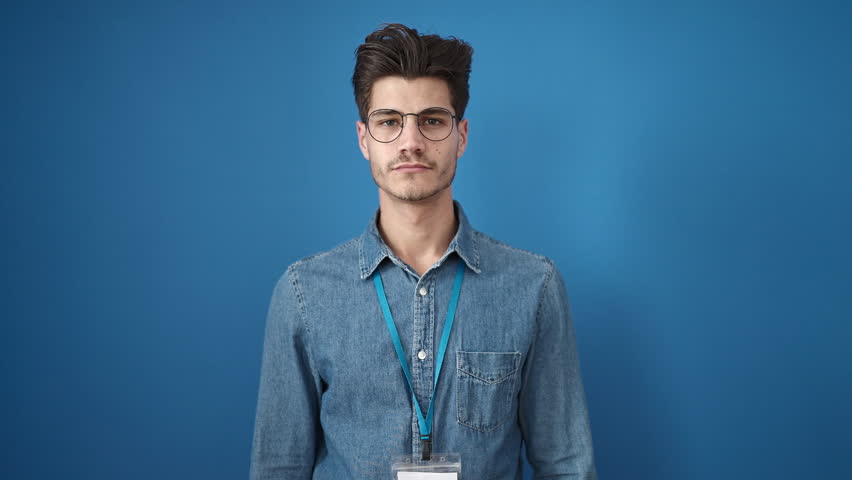 Young hispanic man smiling confident wearing glasses over isolated blue background | Shutterstock HD Video #1100137253