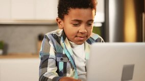 Cute little african american boy using laptop computer browsing web learning reading online social media content looking for toys in internet store at home kitchen Technology addiction concept - Powered by Shutterstock - Get 15% off with code: PIKWIZARD15