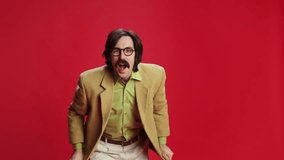 Man with mustache in vintage classic suit emotionally posing over red background. Attentively watching. Concept of emotions, business, occupation, facial expression, fashion. Retro style