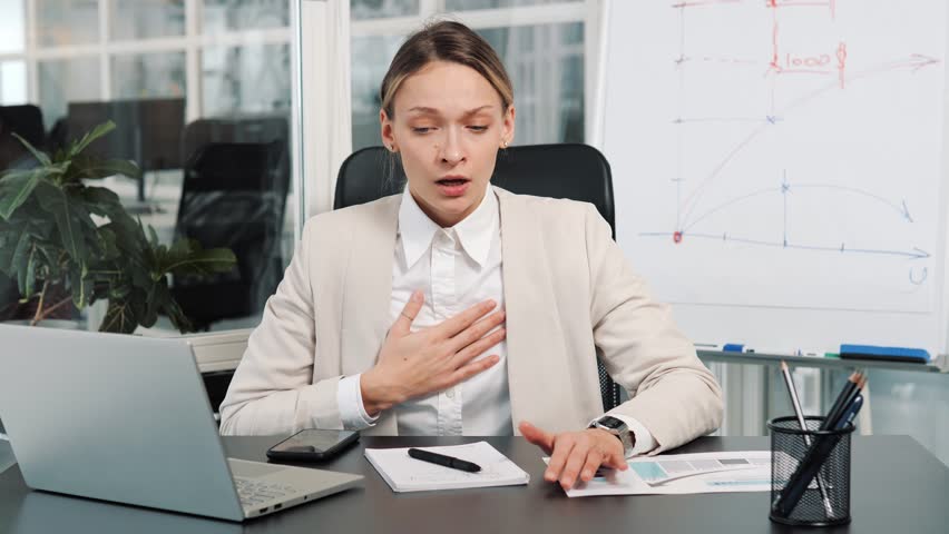 Breathing problems, chest pain, panic attack at work. Business woman has difficulty breathing, female hand touches chest. Heart attack, thoracic osteochondrosis, asthma, osteochondrosis concepts. Royalty-Free Stock Footage #1100139433