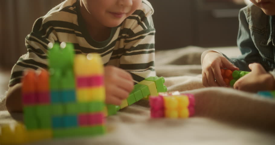 Portrait of Cute Male Asian Child Playing with Colourful Building Blocks in his Room During the Day. Little Boy Dreaming of Becoming a Future Architect. He is Happy About his Creation Royalty-Free Stock Footage #1100144353