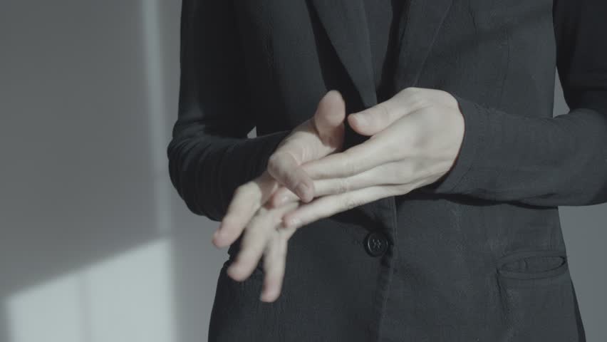 A woman in a business suit is nervous and actively gesticulating. In the frame close-up of the hands at the level of the abdomen. Emotional self-expression. Royalty-Free Stock Footage #1100146127