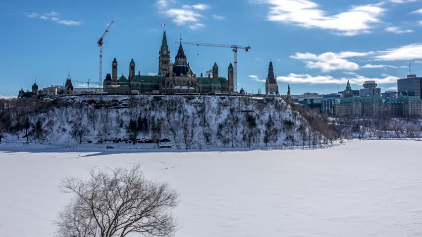 4k timelapse from Majors Hill Park in downtown Ottawa Canada with view to the historical buildings of the Canadian parliament and its surroundings at a cold but sunny day in winter.