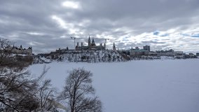 4k timelapse from Majors Hill Park in downtown Ottawa Canada with view to the historical buildings of the Canadian parliament and its surroundings at a cold but sunny day in winter.