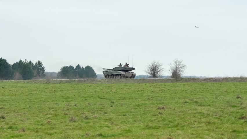 a British army FV4034 Challenger 2 ii main battle tank driving along a dirt track road, Wiltshire UK