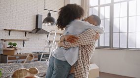 Happy African American loving husband lifts his delightful wife, circles her, shares happiness and positive emotions, moving into new own apartment. The concept of mortgage, real estate. Slow motion - Powered by Shutterstock - Get 15% off with code: PIKWIZARD15
