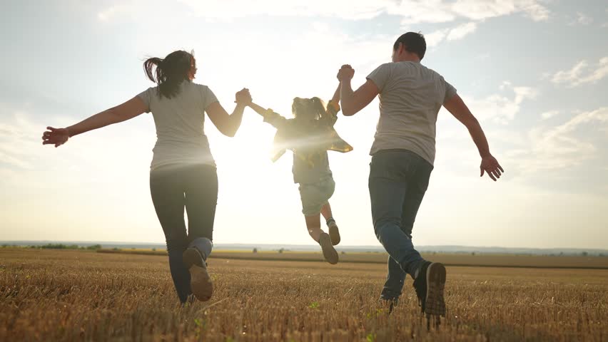 happy family. father mother and daughter together run throw up in park at sunset silhouette. people in park. happy family and little baby child summer. kid dream concept. children run fun Royalty-Free Stock Footage #1100150995