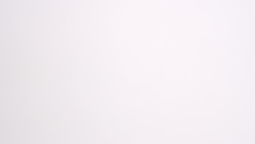 Whole, bright red bell pepper vegetables raining down on white back drop and bouncing into each other in slow motion