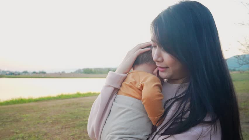 Asian mommy holding her newborn son walking in the morning with beautiful warm sunlight, family warmness vibe, human birth rate, child support, parenting job for single mom. Good memories sharing  | Shutterstock HD Video #1100152337