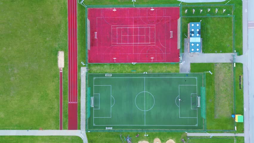 Recreational green grass active sports hockey and football fields overhead top down view. Competition court active outdoor people and children on the field. The Netherlands