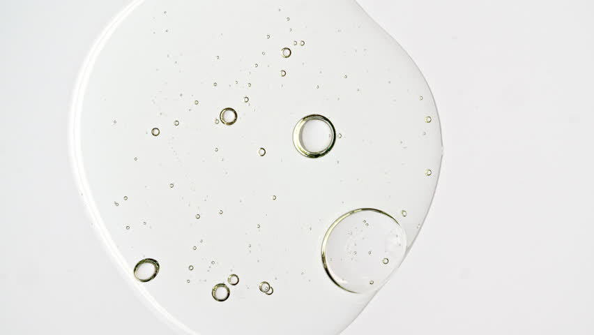 Transparent cosmetic gel fluid with molecule bubbles oil distribution on a white background. Macro Shot of Natural Organic Cosmetics, Medicine. Production Close-up. Slow Motion. High quality 4k | Shutterstock HD Video #1100152987