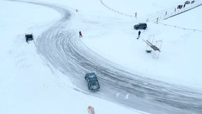 Aerial view of drifting cars on the snow covered off road. Clip. Winter race on a frozen lake.