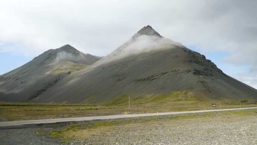 Driving a car in Iceland. Iceland road landscape with stunning mountains around. Iceland nature. High quality 4k footage