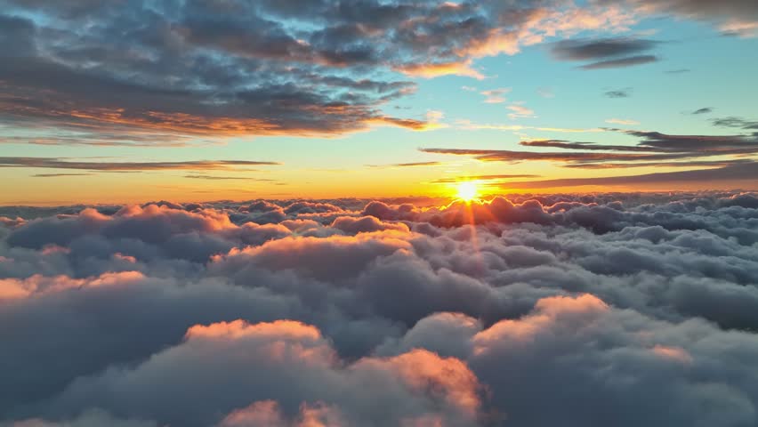 Epic sunset over the clouds. Flight in the sky at sunset, view from window of airplane. Warm sun sets over the horizon in clouds. UHD, 4K