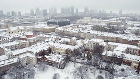 Aerial video of snow-covered rooftops and streets of the city with the city centre in the background. Winter city concept. . High quality 4k footage