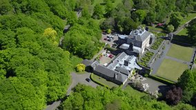 Aerial pullback view over pollock house famous country mansion surrounded by vegetation and a river on the countryside of Glasgow