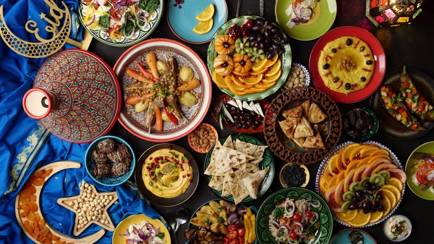 Table prepared for dinner in Ramadan with dates, lamb in tagine, hummus, samosa, falafel, pita bread. Muslim family dinner. Islamic holiday Eid al Fitr Royalty-Free Stock Footage #1100170649