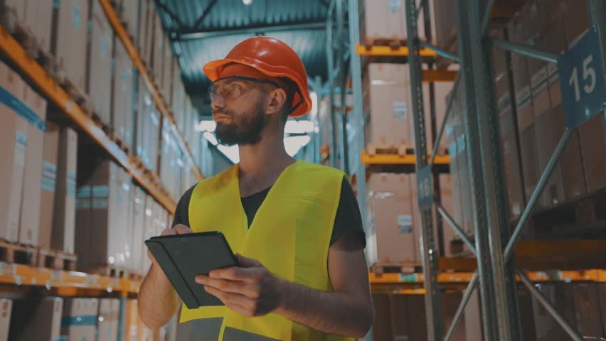A manager with a tablet in a warehouse checks the goods. Warehouse manager of a large factory. | Shutterstock HD Video #1100172601