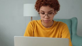 African american girl using laptop at home office looking at screen typing chatting reading writing email. Young woman having virtual meeting online chat video call conference. Work learning from home