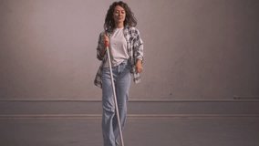positive girl holding a mop and dancing. live video. High quality Full HD video recording