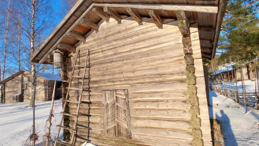 Wooden rustic buildings from the 1800s in Finland, these old log buildings represent peasant times in Finland and in Nordic countries in general, this village was shot on a sunny winter day   
