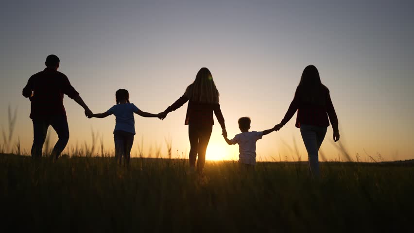 Happy family silhouette outdoors in park. family runs at sunset hand in hand together. family runs at sunset with children. Happy children father run in nature. Happy walk in park holding hand father. Royalty-Free Stock Footage #1100179579