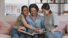 Recall the past life memories Happy time Mother's day grown up kid child joy fun look at old retro photo album with mature mum. Asia adult people middle age mom smile enjoy relax sitting at home sofa. - Powered by Shutterstock - Get 15% off with code: PIKWIZARD15