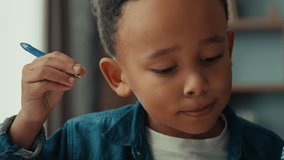 Concentrated smart African American schoolboy Latin preteen school boy pupil child studying lesson writing with pen. Serious kid primary class student write exercise homework home learning education - Powered by Shutterstock - Get 15% off with code: PIKWIZARD15