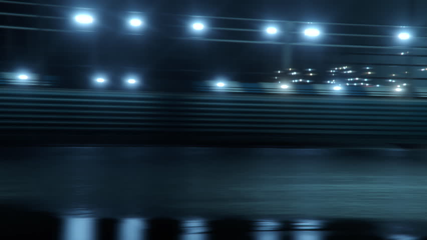 Accelerating High Performance Electric Racing Car is Driving on Track at Night Time. Camera follows the Vehicle. Royalty-Free Stock Footage #1100194059