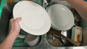 Man washing dishes in the kitchen, top view. Caucasian man washing dishes in the kitchen after cooking and eating to happy family to eat slow motion video - Powered by Shutterstock - Get 15% off with code: PIKWIZARD15