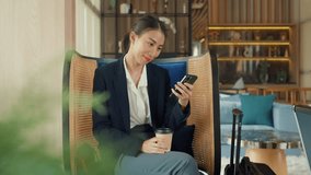 Youth Asia business female passenger wear suit sit on couch chair drink tea play phone look online booking ticket in modern airline lounge wait for transit at airport. Travel business trip concept. - Powered by Shutterstock - Get 15% off with code: PIKWIZARD15