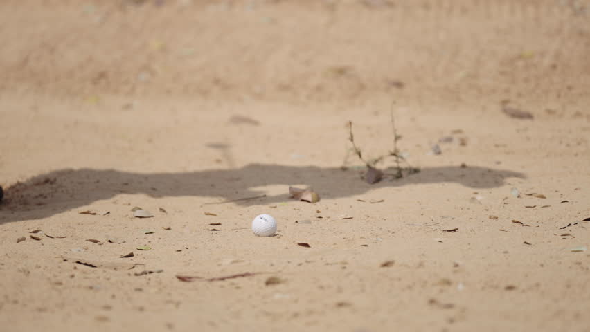 Closeup shot of asian Thai young male golfer tapping the golf ball into a hole at golf course