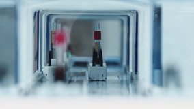 Test tube moving away on and automatic holder and turning right out of sight. Blurred foreground. Lab concept. High quality 4k footage