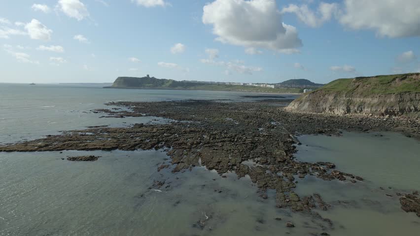 Aerial approach view of North bay, Scarborough, North Yorkshire with cliffs, coastline, ocean, and castle
