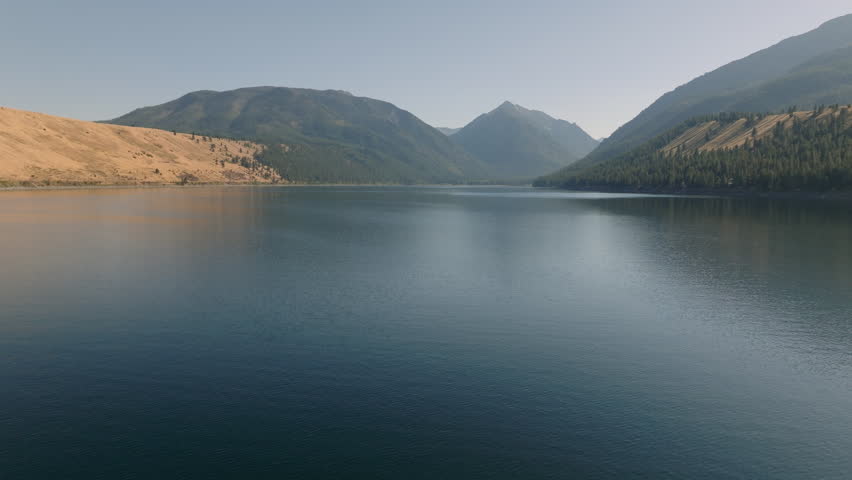 Aerial Over Stunning Ribbon Lake with Hazy Mountains In Background