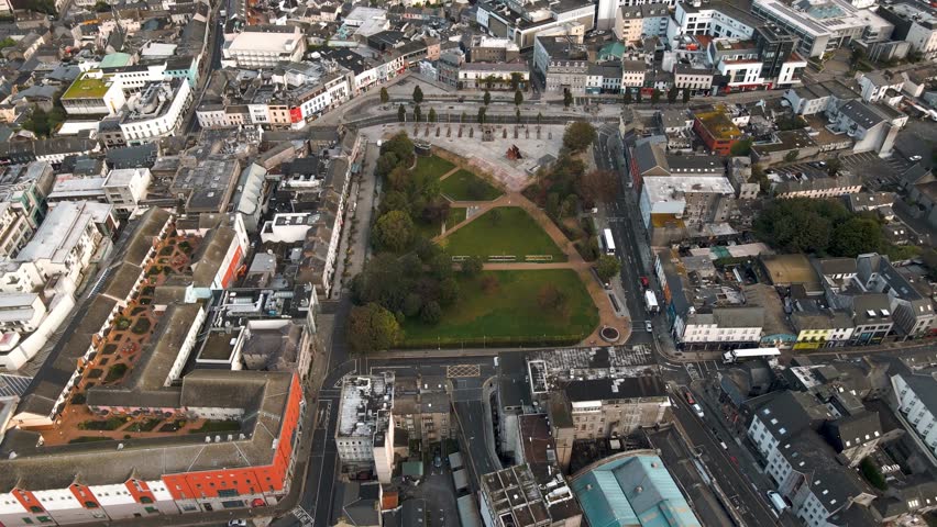 Aerial drone tracking shot moving away from Eyre Square park in Galway City