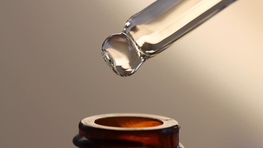 Cosmetic dropper with essential oil dripping into a brown bottle, macro. Serum, peptide, beauty concept. Royalty-Free Stock Footage #1100208185