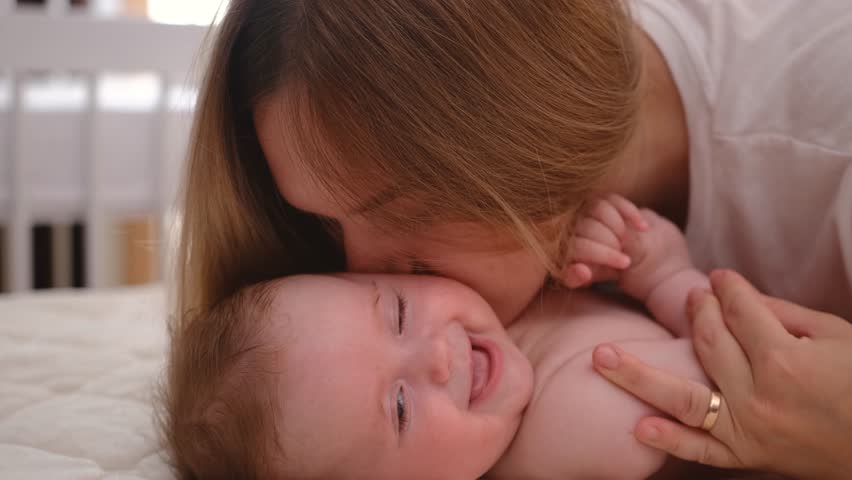 Mother kissing happy baby laughing enjoying loving mom nurturing toddler at home | Shutterstock HD Video #1100212347