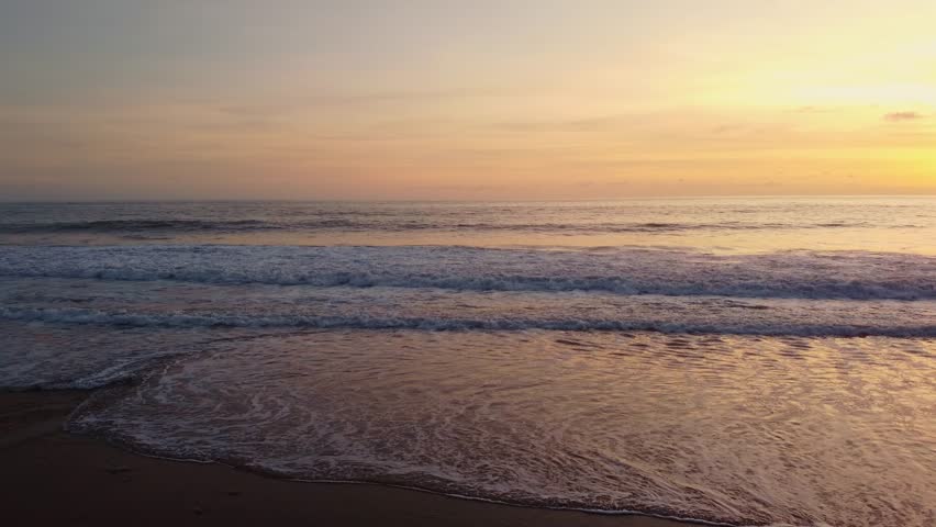 Aerial view of Bali beach island and sliver of sand on Sunset beach in the evening, sunset sea view with mountains, drone aerial.