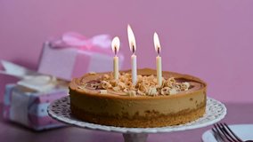 Three burning candles on birthday cheesecake pink background - Powered by Shutterstock - Get 15% off with code: PIKWIZARD15