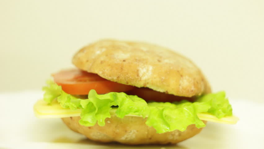Bright video of a man making healthy vegetarian burger with cheese, tomatoes and salad | Shutterstock HD Video #1100217295