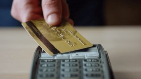 Man hands making contactless payment with credit card at machine terminal on table close up. Unknown client paying bill by touching card to wireless reader bank pos device. Cashless nfc technology. - Powered by Shutterstock - Get 15% off with code: PIKWIZARD15