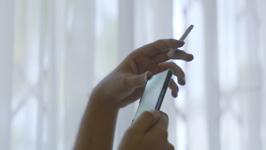 Man Smoking Cigarette Close Up while using phone | Shutterstock HD Video #1100220347