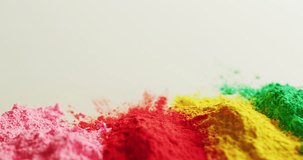 Video of multi coloured powders with copy space on white background. Holi festival, hindu tradition and celebration concept