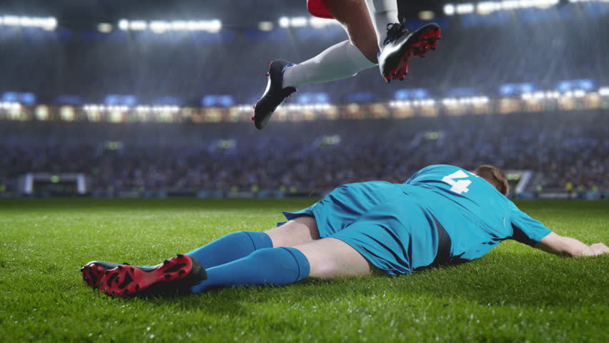 Aesthetic Shot of Red Team Soccer Football Player Successfully Avoiding Sliding Tackle From Opponent on Stadium With Fans Cheering. Super Slow Motion Captures Dangerous Moment During Championship. | Shutterstock HD Video #1100229003