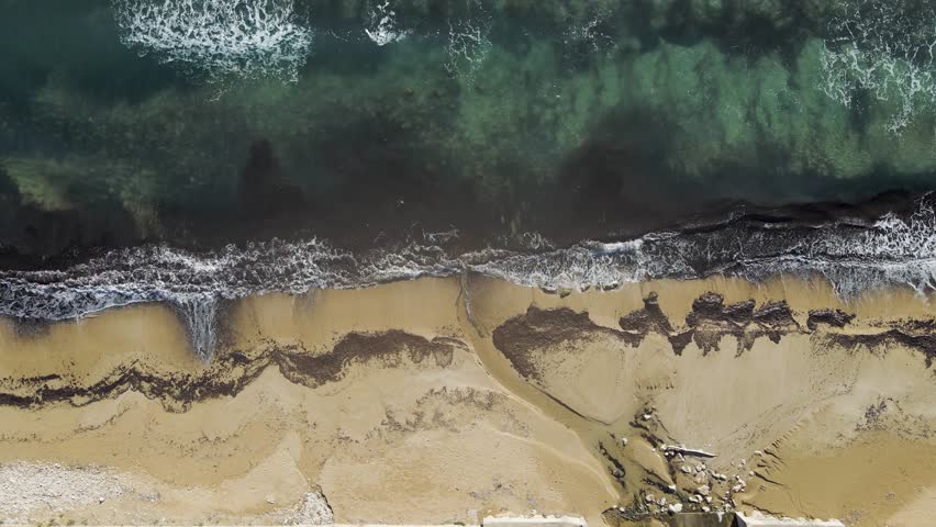 Aerial view of waves crashing on the shoreline along the Mediterranean Sea, Avola, Syracuse, Sicily, Italy.
