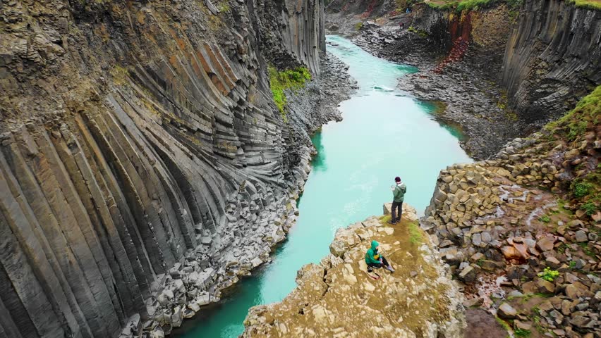 Aerial view of people standing at Studlagil Canyon in the Glacier Valley Jokuldalur, Eastern Iceland. Royalty-Free Stock Footage #1100231413