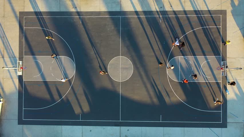 Aerial view of people playing basketball along the beach at sunset, Venice Beach, California, United States.