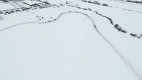 Slow motion of a racing cars championship sliding on an ice track. Clip. Winter drift competitions, aerial view.