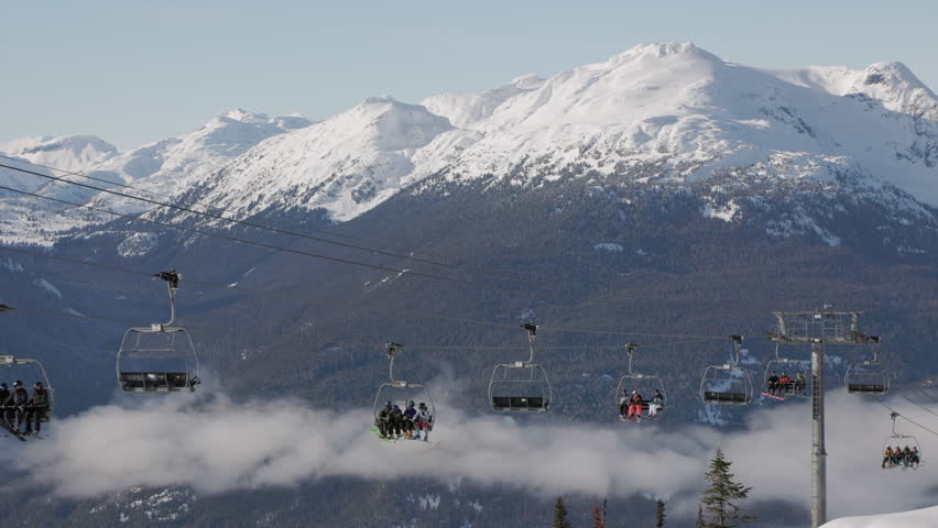 Mountain peak and chair lift with skiers, winter landscape, ski resort, Whistler BC. 4K 24FPS